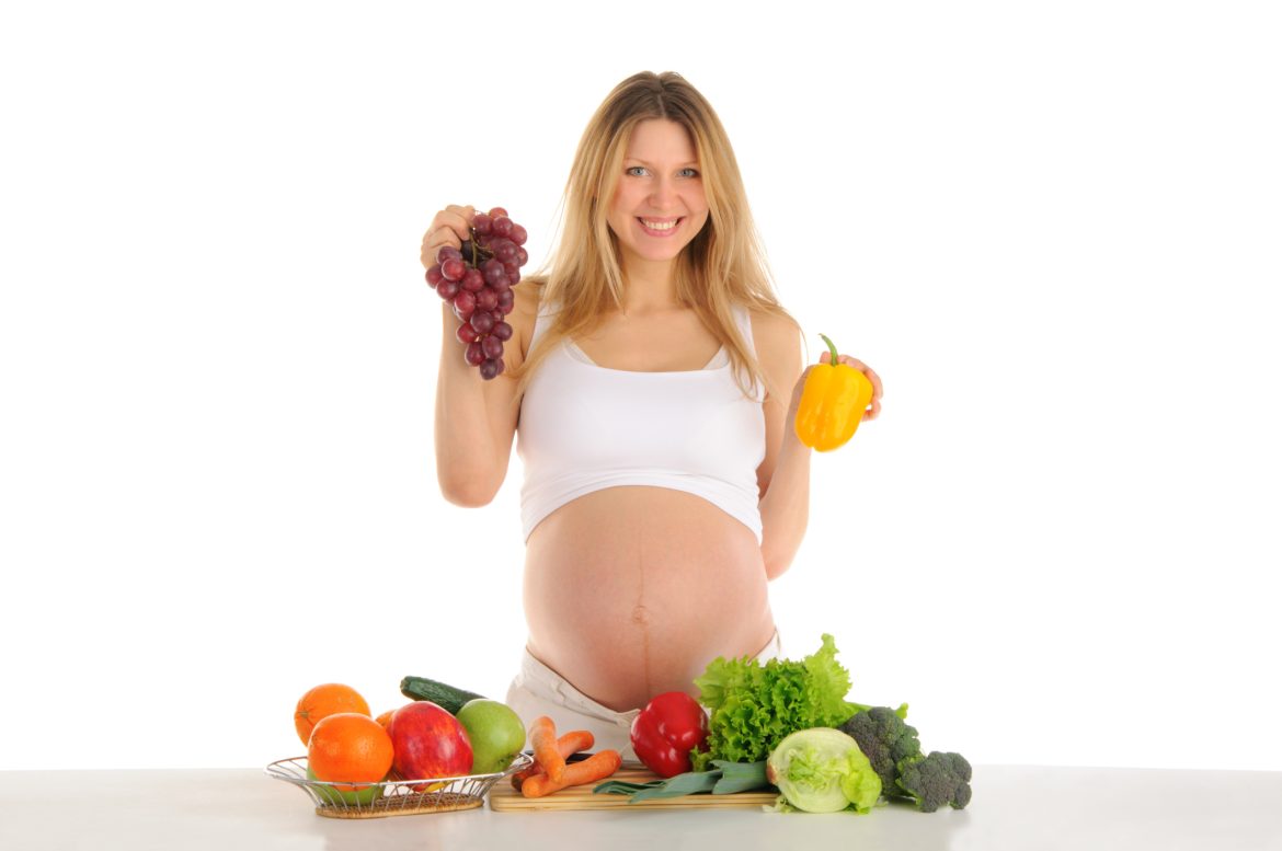 Happy pregnant woman with fruits and vegetables vegan pregnancy